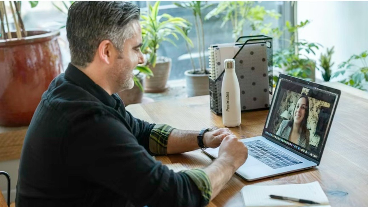 Man on a Zoom call with a woman.